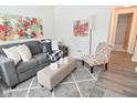 Cozy living room featuring a gray sofa and patterned armchair at 5325 Oliver Ave, Indianapolis, IN 46241