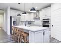 Modern kitchen with white cabinets, stainless steel appliances, and an island with seating at 5780 Stetson Dr, Whitestown, IN 46052