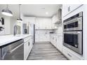 Modern kitchen with white cabinets, stainless steel appliances and hardwood floors at 5780 Stetson Dr, Whitestown, IN 46052