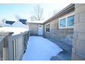 White front door entry with stone exterior and snowy walkway at 67 W Brookville Rd, Fountaintown, IN 46130