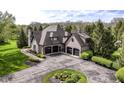 Aerial view of a large home with a well-manicured lawn, circular driveway, and mature trees at 14990 E 104Th St, Fishers, IN 46040