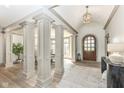 Elegant foyer featuring high ceilings, decorative columns, hardwood floors, and a wooden front door at 14990 E 104Th St, Fishers, IN 46040