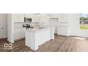 Modern kitchen with white cabinets, island, and stainless steel appliances at 1910 Black Oak Dr, Shelbyville, IN 46176