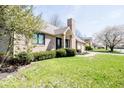Beautiful brick home with a well-maintained lawn, lush landscaping, and an attached garage at 1966 Broadmoor Ln, Columbus, IN 47203