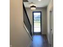 Home entryway featuring wood-look flooring, modern lighting, and access to the staircase at 373 S Cherry St, Westfield, IN 46074