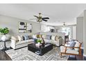 Bright living room features modern decor, comfortable seating, stylish rug, and seamless flow to the adjacent kitchen and dining area at 5327 Milhouse Rd, Indianapolis, IN 46221