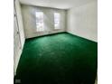 Spacious living room featuring green carpet and large windows at 1125 Laurel St, Indianapolis, IN 46203