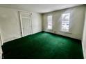 Living room with green carpet and two windows at 1125 Laurel St, Indianapolis, IN 46203
