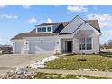 Two story home with gray brick and three car garage at 17105 Silo Ridge Way, Noblesville, IN 46060