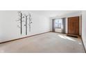 Spacious living room with neutral carpeting and a tree wall decal at 1902 Alhambra Dr, Anderson, IN 46013