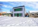 Modern two-story home with blue siding and green accents, snowy front yard at 2939 Ralston Ave, Indianapolis, IN 46218