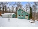 Teal house exterior with attached garage, deck, and stairs. Winter scene at 3764 Glenwood Dr, Martinsville, IN 46151
