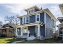 Charming blue two-story home with white trim, inviting front porch and landscaped yard at 404 N Gray St, Indianapolis, IN 46201