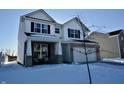 Two-story home with white siding, brick accents, and a two-car garage at 6823 Aster Dr, Pendleton, IN 46064