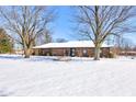 Brick ranch home with a snow covered lawn at 6932 W Jennifer Ln, Greenfield, IN 46140