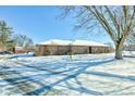 Brick ranch home with snow covered driveway at 6932 W Jennifer Ln, Greenfield, IN 46140