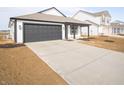 Single-story home featuring gray garage door, covered porch, and concrete driveway, ready for new owners at 1232 Fleming Dr, Greenfield, IN 46140