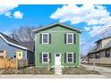 Charming two-story home featuring bright green siding, a white door, and black shutters at 1446 E Naomi St, Indianapolis, IN 46203