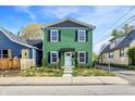 Charming two-story home featuring a vibrant green exterior with black shutters and a well-maintained front yard at 1446 E Naomi St, Indianapolis, IN 46203