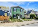 Charming two-story home featuring a vibrant green exterior with black shutters and a well-maintained front yard at 1446 E Naomi St, Indianapolis, IN 46203