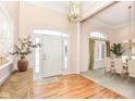 Bright entryway with hardwood floors, chandelier, and view of dining room at 14580 Adios Pass, Carmel, IN 46032