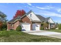 Brick ranch home with two-car garage and landscaping at 14580 Adios Pass, Carmel, IN 46032