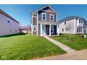 Beautiful two-story home featuring green grass, neat landscaping, and an inviting entrance way at 1713 Real St, Indianapolis, IN 46240
