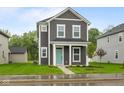 Charming two-story home with gray siding, white trim, and a welcoming turquoise front door at 1713 Real St, Indianapolis, IN 46240