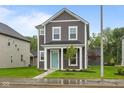 Charming two-story home with gray siding, white trim, and a welcoming turquoise front door at 1713 Real St, Indianapolis, IN 46240