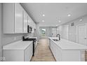 Modern kitchen with white cabinets, quartz countertops, stainless steel appliances and hardwood floors at 1713 Real St, Indianapolis, IN 46240