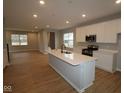 Bright open kitchen featuring a large island, stainless appliances, and modern white cabinets at 1713 Real St, Indianapolis, IN 46240