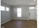 Spacious living room featuring wood-look flooring, large windows for natural light, and a welcoming entrance at 1713 Real St, Indianapolis, IN 46240