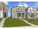 Green two-story house with white trim, a front porch, and a neatly landscaped lawn at 1717 Real St, Indianapolis, IN 46240