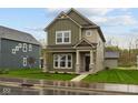 Two-story home showcasing an inviting covered front porch and a well-manicured lawn at 1717 Real St, Indianapolis, IN 46240