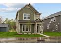 Two-story home showcasing an inviting covered front porch and a well-manicured lawn at 1717 Real St, Indianapolis, IN 46240