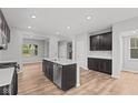 Modern kitchen features an island with stainless steel appliances and dark cabinetry at 1717 Real St, Indianapolis, IN 46240