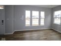 Bright living room with multiple windows allowing for an abundance of natural light and hardwood floors at 1717 Real St, Indianapolis, IN 46240
