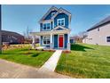 Inviting two-story home featuring blue siding, white trim, a red front door, and a neatly landscaped front yard at 1721 Real St, Indianapolis, IN 46240