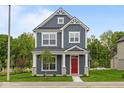 Charming two-story home with a red front door, gray siding, white trim, and manicured lawn at 1721 Real St, Indianapolis, IN 46240