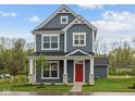 Charming two-story home featuring a striking red door, stone accents, and beautiful curb appeal at 1721 Real St, Indianapolis, IN 46240