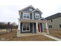 Charming two-story home boasts a modern exterior with a welcoming front porch and red front door at 1721 Real St, Indianapolis, IN 46240