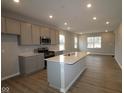 Bright kitchen features sleek appliances, quartz countertops, and a large center island overlooking living area at 1721 Real St, Indianapolis, IN 46240