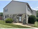Two-story townhouse with stone facade, horizontal siding and manicured lawn and shrubs at 2634 Country Estates Dr # 17, Indianapolis, IN 46227