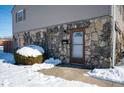 Stone and siding exterior with a brown door and snowy landscaping at 2634 Country Estates Dr # 17, Indianapolis, IN 46227