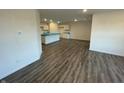 Open-concept living room with wood-look flooring and recessed lighting, leading to the kitchen at 6636 Sulgrove Pl, Indianapolis, IN 46221