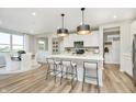 Spacious kitchen boasts white cabinets, island, stainless steel appliances, and hardwood floors at 7194 Firestone Rd, Whitestown, IN 46052