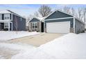 Gray sided home with stone accents, two car garage, and snowy landscape at 829 Stark St, Greenfield, IN 46140