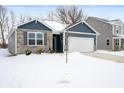 Two-story home with gray siding, stone accents, and a two-car garage at 829 Stark St, Greenfield, IN 46140