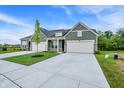 Wide view of two homes with green siding, attached garages, and a concrete driveway at 9711 Palermo Ave, Indianapolis, IN 46239