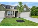Attractive home exterior showcasing a well-manicured lawn, a two-car garage, and modern green siding at 9711 Palermo Ave, Indianapolis, IN 46239